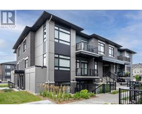 A modern multi-story residential building with balconies and a black railing.