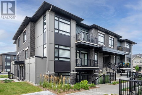 A modern multi-story residential building with balconies and a black railing.