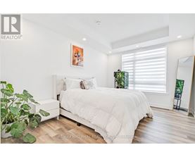 A bedroom with a large bed and a potted plant.