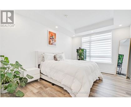 A bedroom with a large bed and a potted plant.