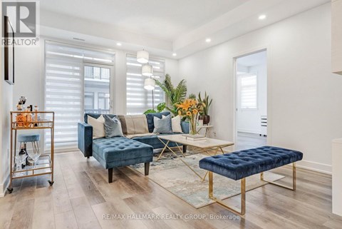 A living room with a blue couch and a gold side table.