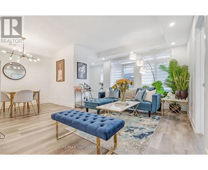 A living room with a blue ottoman and a white chair.