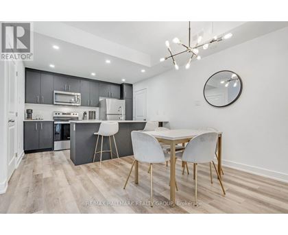 A modern kitchen with a dining table and chairs.