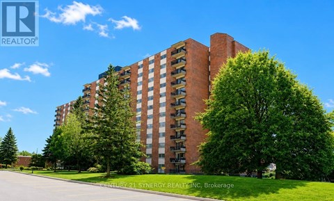 A tall red brick building with trees in front of it.