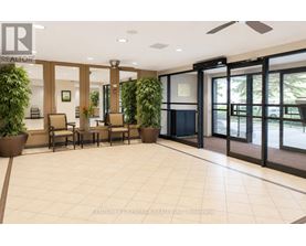 A lobby with a tile floor and a ceiling fan.