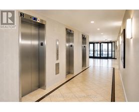A hallway with elevators and a sign that says "REALTOR".