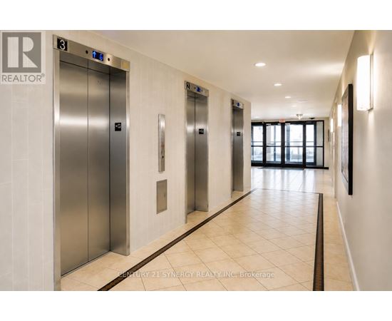 A hallway with elevators and a sign that says "REALTOR".