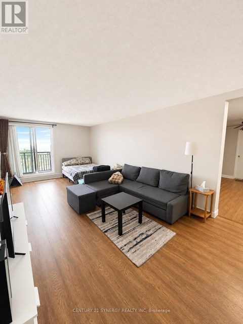 A living room with a grey couch and a wooden floor.