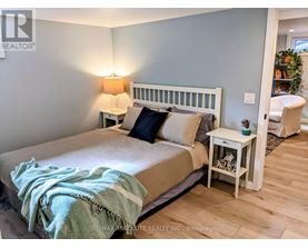 A bedroom with a bed, nightstand, and lamp.