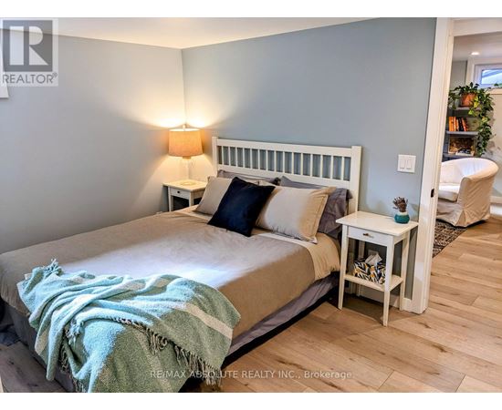 A bedroom with a bed, nightstand, and lamp.