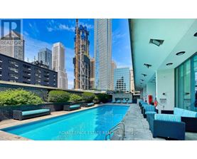 A swimming pool is surrounded by lounge chairs on the roof of a building.