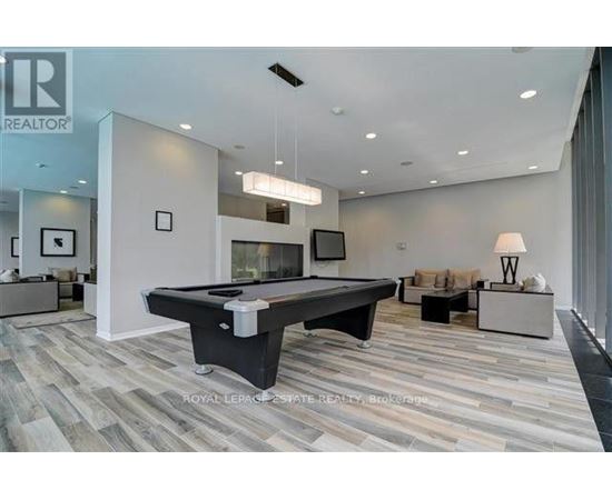 A spacious living room with a pool table and a television.