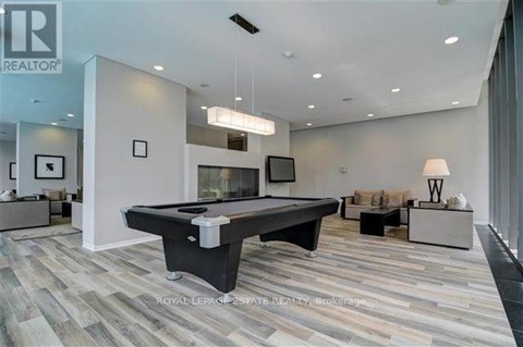 A spacious living room with a pool table and a television.