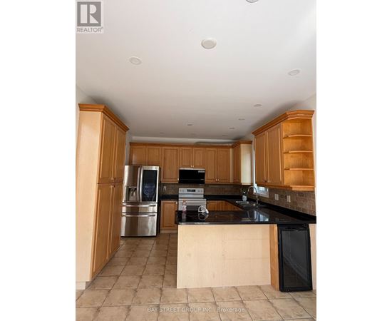 A kitchen with wooden cabinets and a black counter top.