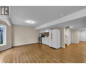 A kitchen area with white appliances and wooden flooring.