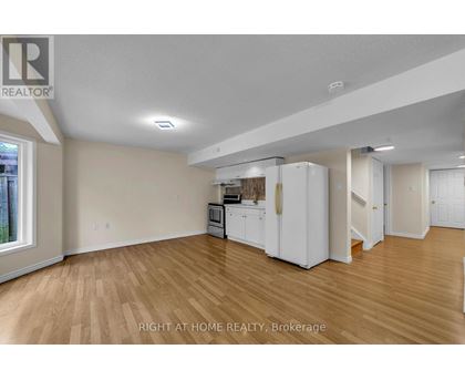 A kitchen area with white appliances and wooden flooring.