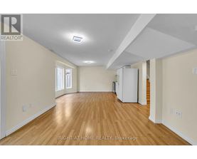 A spacious room with wooden floors and white walls.