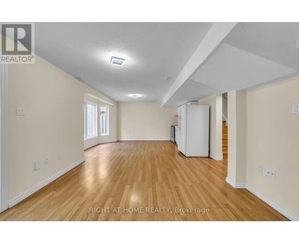 A spacious room with wooden floors and white walls.