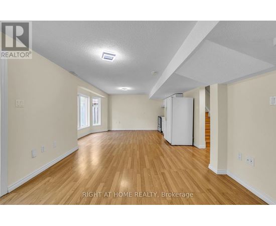 A spacious room with wooden floors and white walls.
