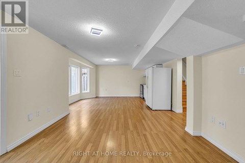 A spacious room with wooden floors and white walls.
