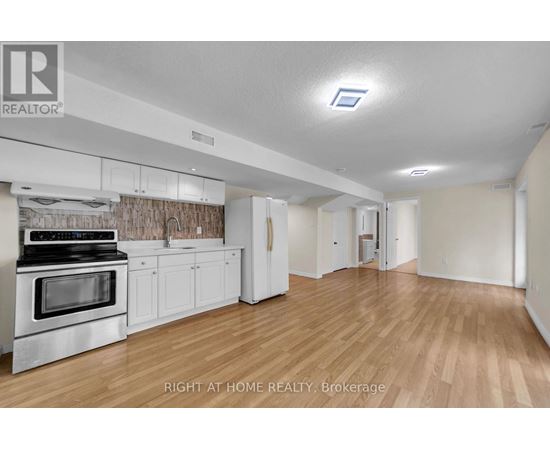 A kitchen with white cabinets and a stove top oven.