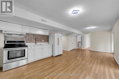 A kitchen with white cabinets and a stove top oven.