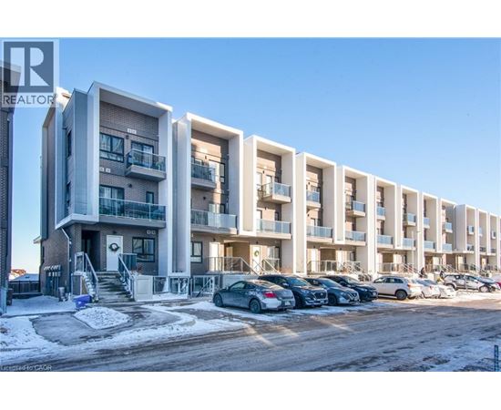 A row of modern apartment buildings with cars parked in front.