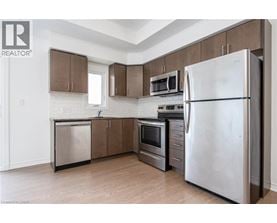A kitchen with a refrigerator, microwave, oven, and dishwasher.