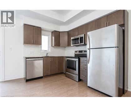 A kitchen with a refrigerator, microwave, oven, and dishwasher.