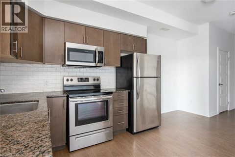 A kitchen with a stove, oven, refrigerator, and microwave.