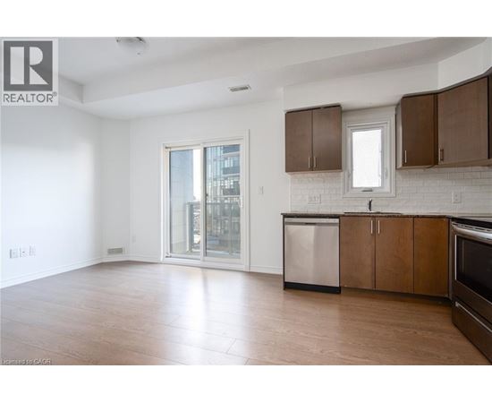 A spacious kitchen with wooden cabinets and a stainless steel dishwasher.