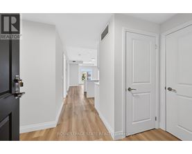 A hallway with white doors and a black door on the left.