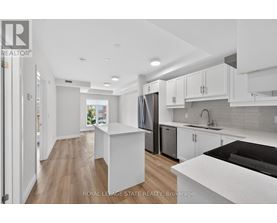 A modern kitchen with white cabinets and a black countertop.