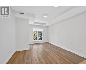 A spacious room with wooden flooring and white walls.
