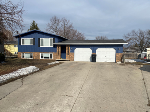 A blue house with a white garage door.