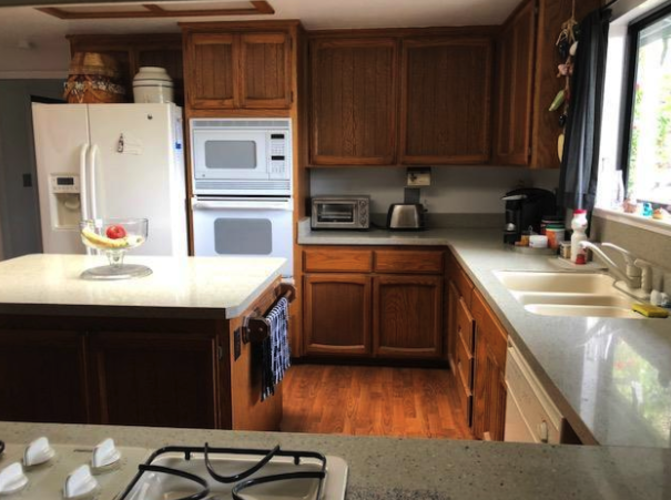 A kitchen with wooden cabinets and a white refrigerator.