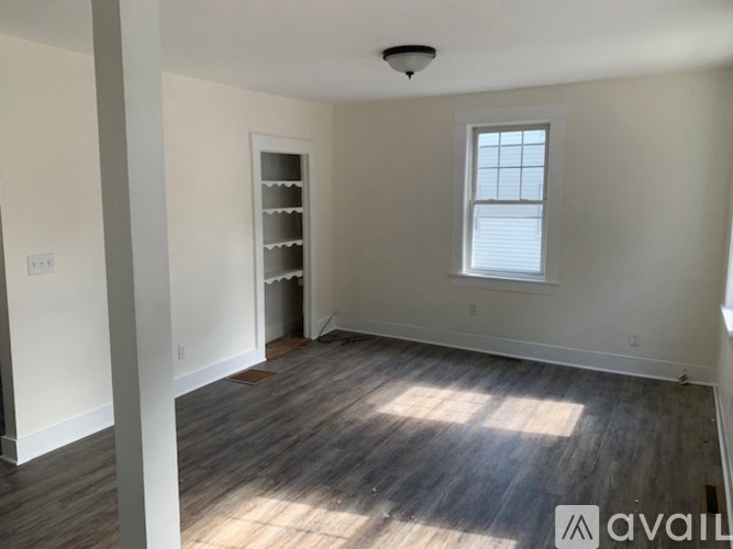 A room with wooden flooring and a window is available for rent.
