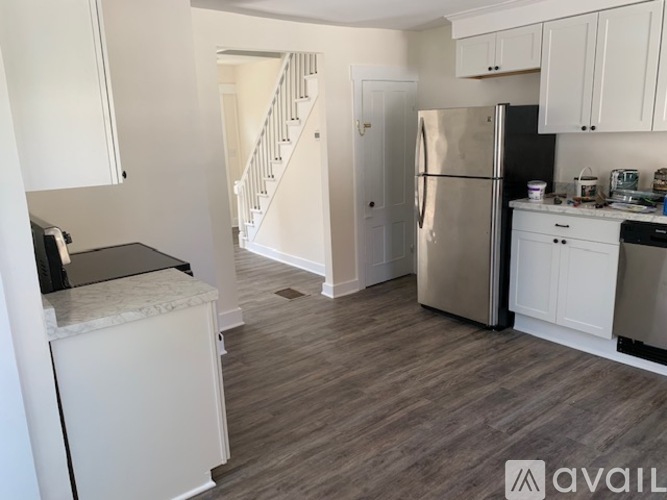 A kitchen with a refrigerator, stove, and cabinets.