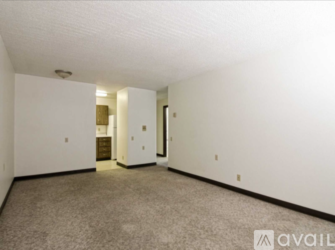 A spacious room with carpeted floor and white walls.
