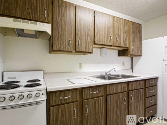 A kitchen with wooden cabinets and a white stove top oven.