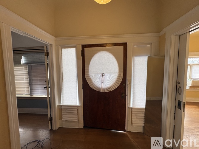 A room with a brown door and a white circular window.