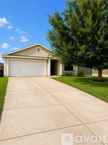 A house with a garage and a driveway in front of it.