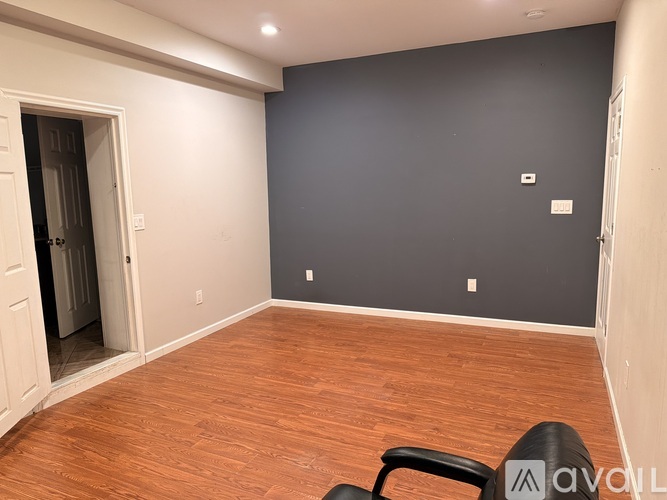 A room with wooden flooring and a white door.