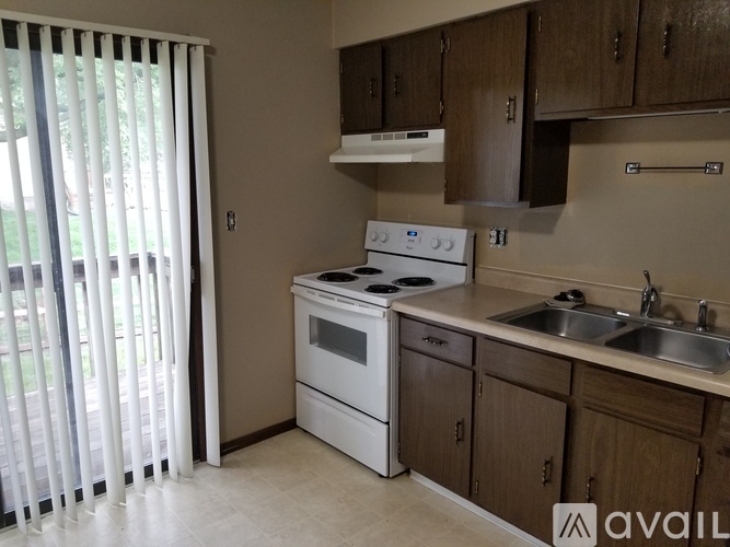 A kitchen with a white stove top oven and a sink.