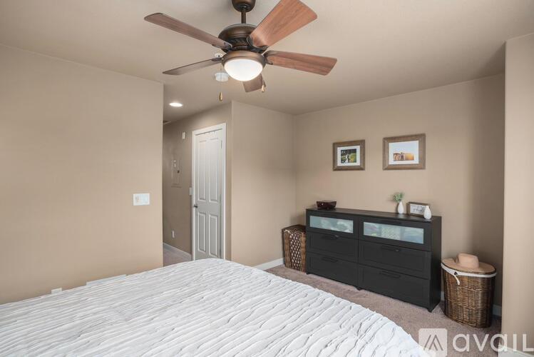 A bedroom with a large bed and a ceiling fan.