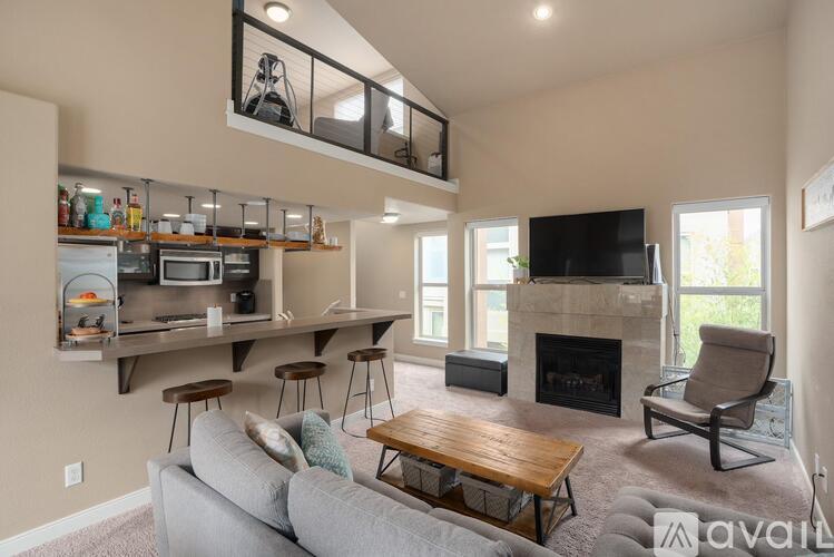 A living room with a grey couch, a wooden coffee table, and a fireplace.