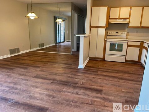 A kitchen with white cabinets and a wood floor.