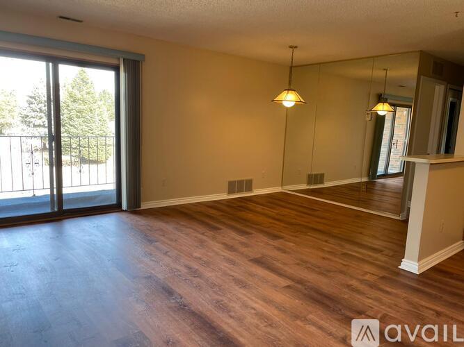 A room with wooden floors and a sliding glass door leading outside.