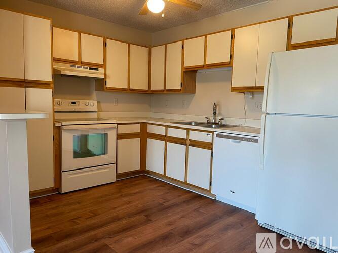 A kitchen with wooden cabinets and white appliances.