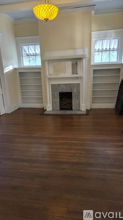 A room with a fireplace and wooden floors.